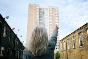 Frances Day pointing to the flat she was once held out of, Boothtown Flats. 2024.